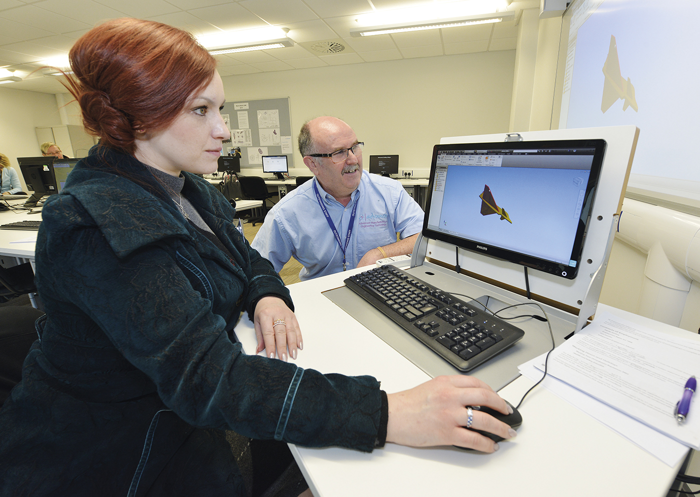 Student and teacher rendering a 3D model on computer in classroom